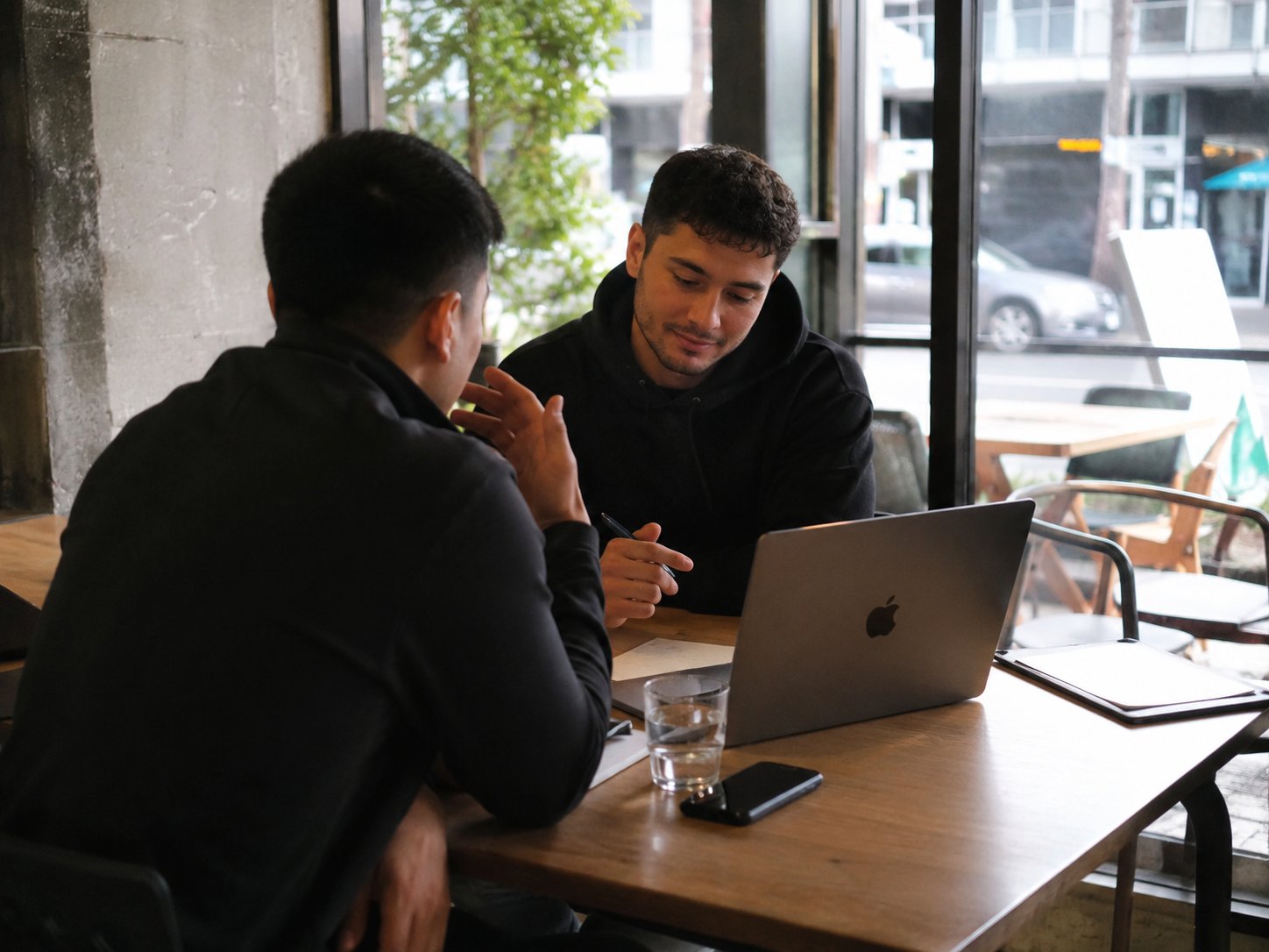 Two people reviewing a client's numbers together at a table with a laptop